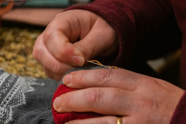 a person with a pair of scissors cutting a piece of fabric